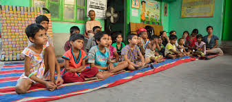 Three women sitting and smiling outdoors.
